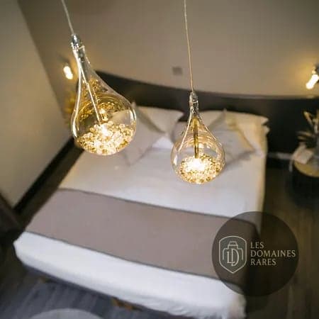 Chambre avec lit et suspensions lumineuses