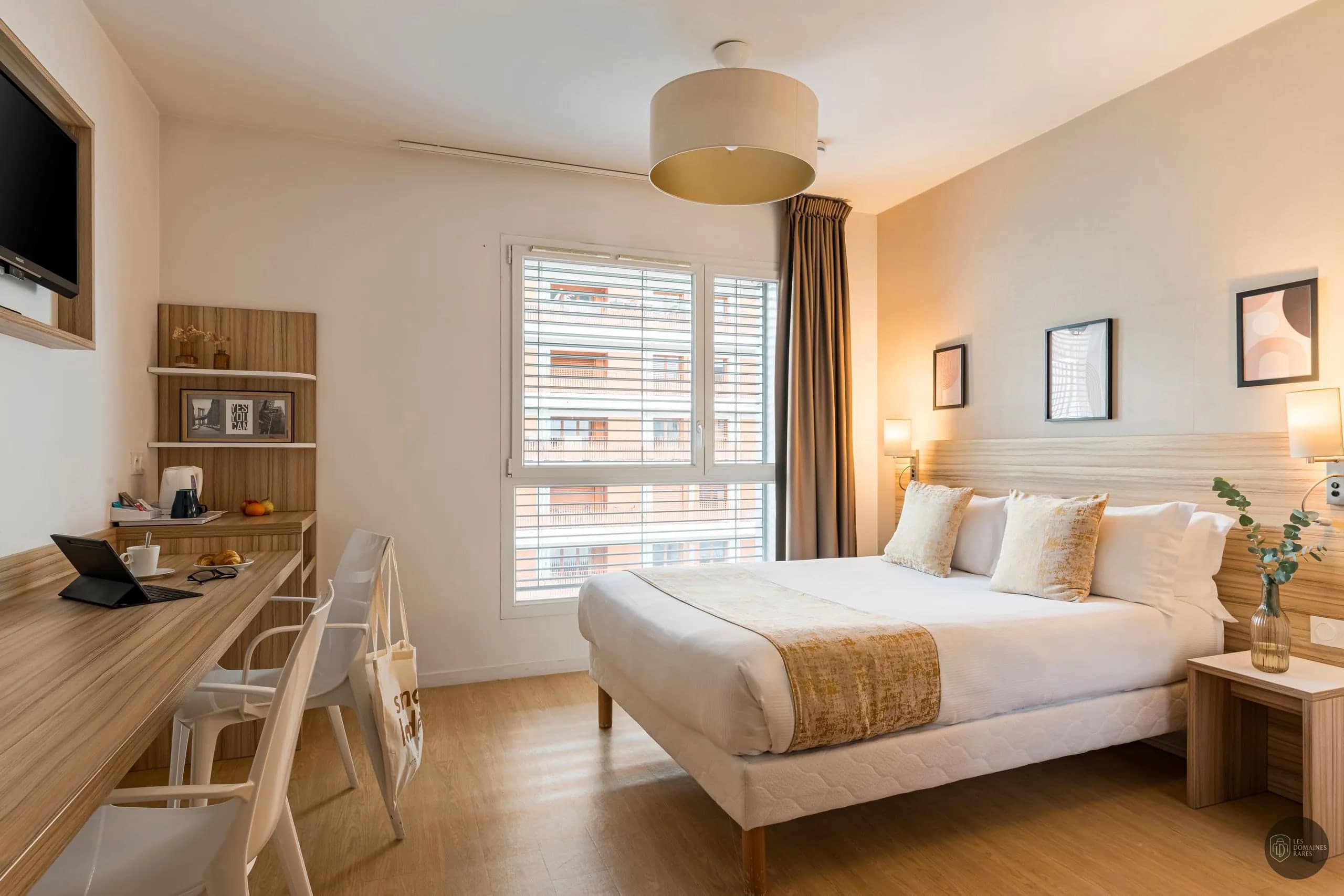 Chambre lumineuse avec lit et bureau