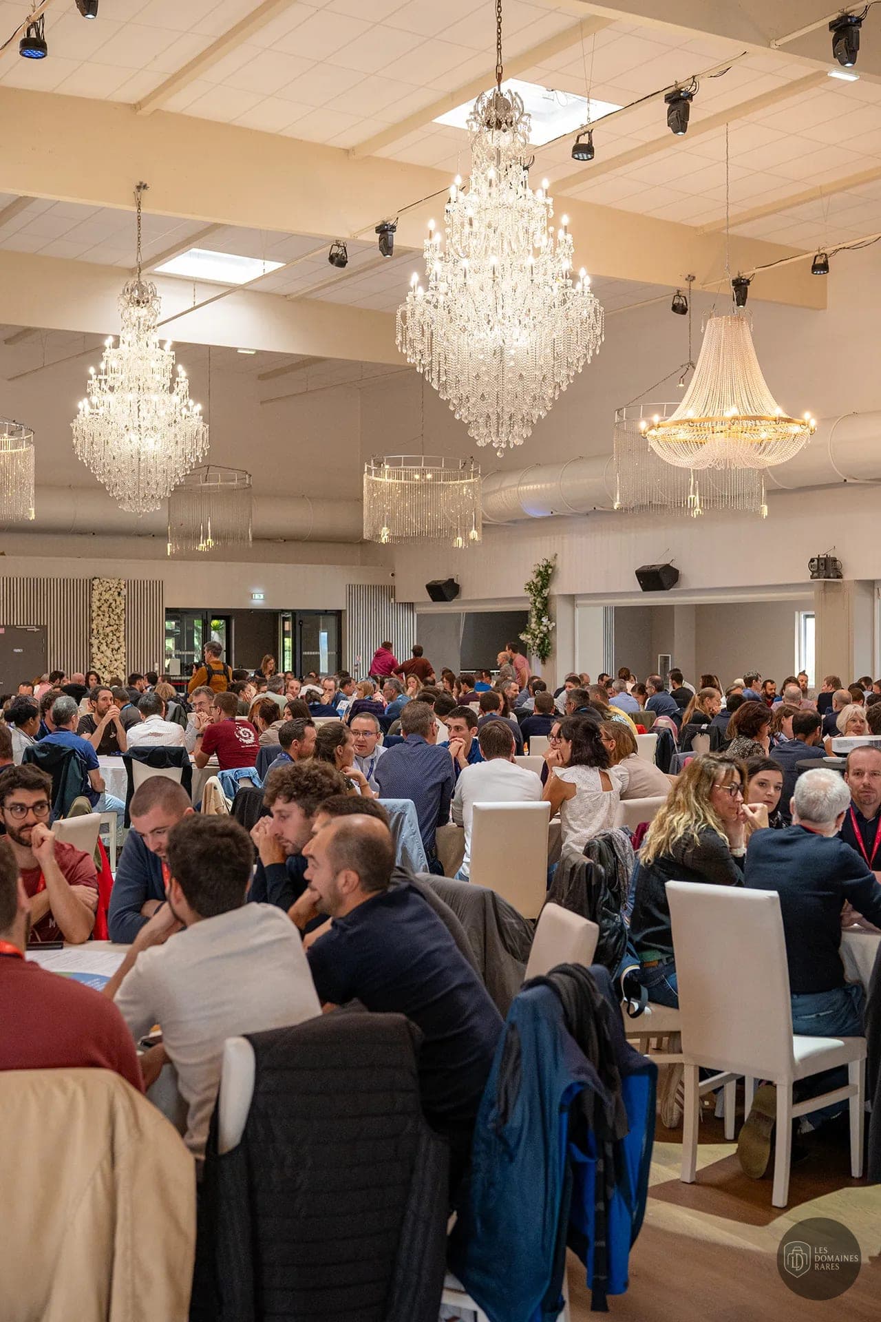 Grande salle avec tables et participants