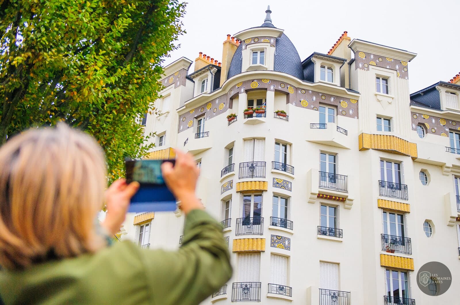 Femme prenant une photo d'un bâtiment