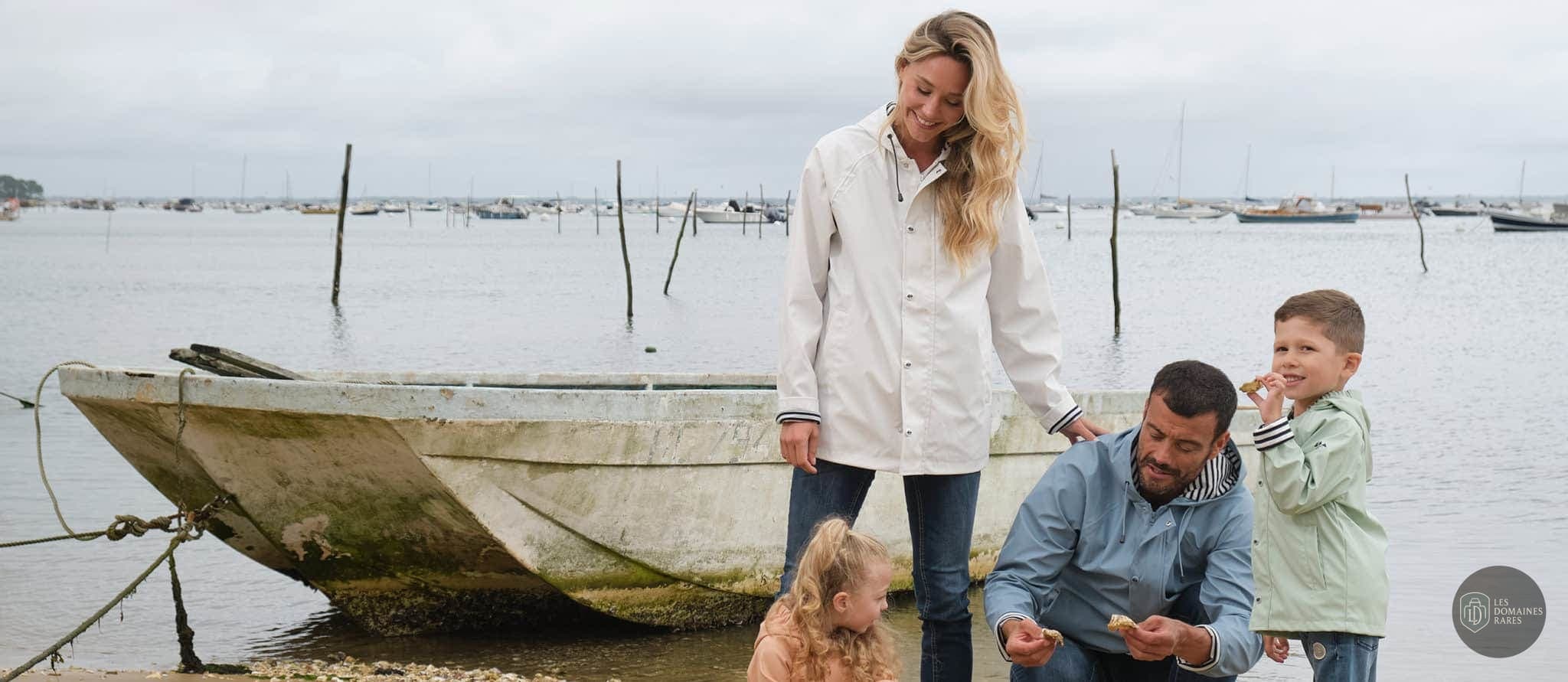 Famille près d'une barque, bord de mer