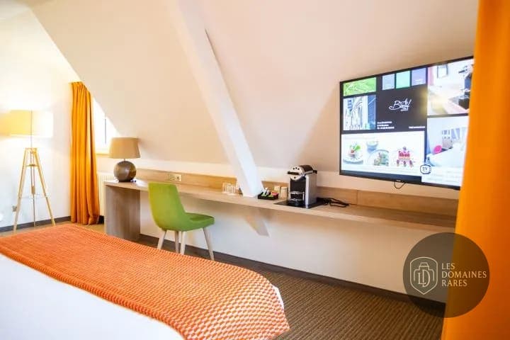 Chambre mansardée avec bureau et télévision