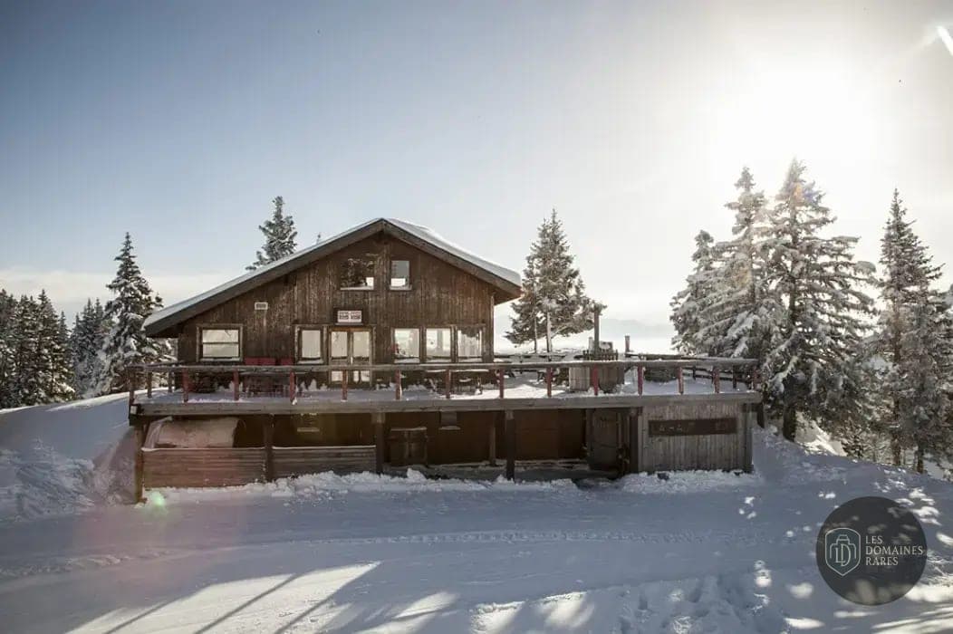 Chalet enneigé avec terrasse et arbres
