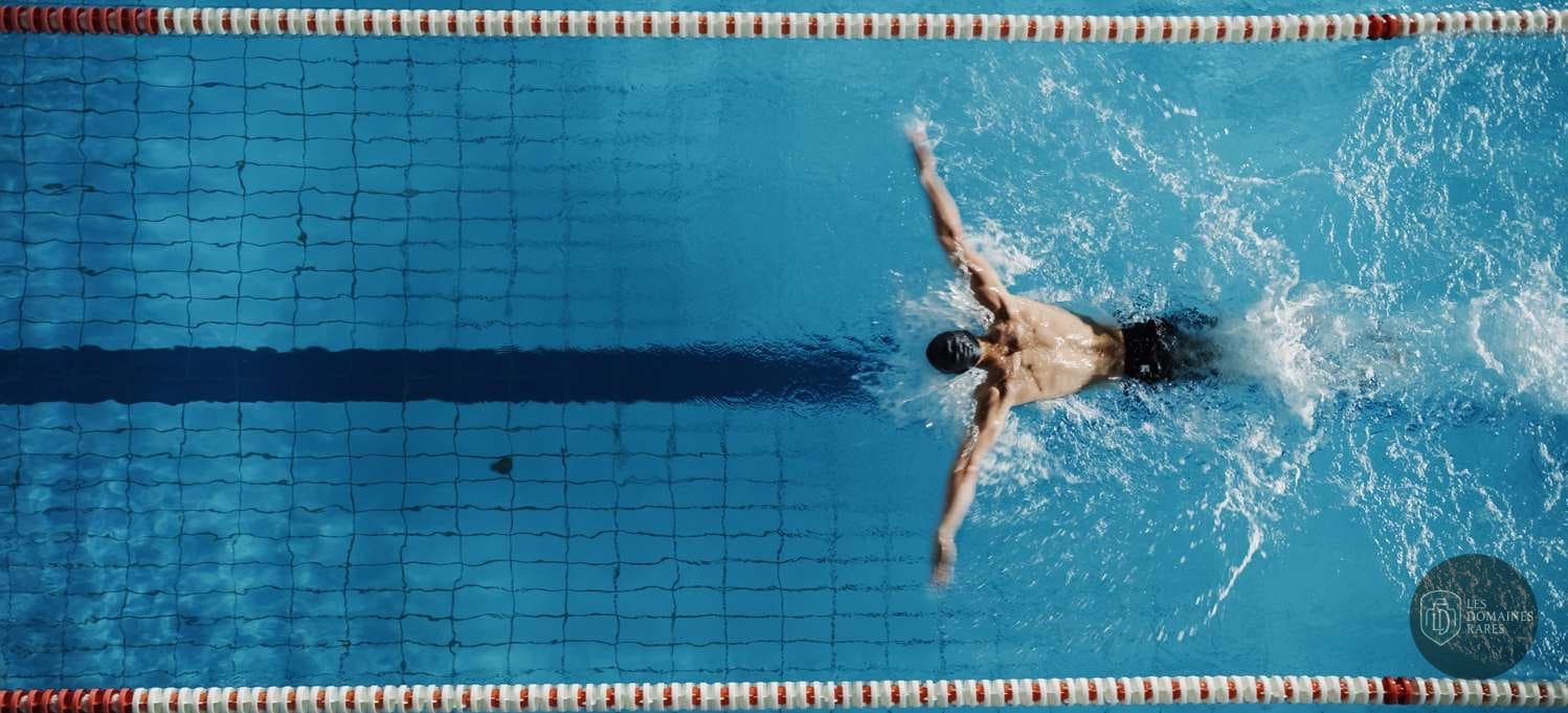 Homme nageant dans une piscine