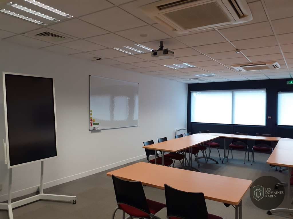 Salle de réunion avec tables et projecteur