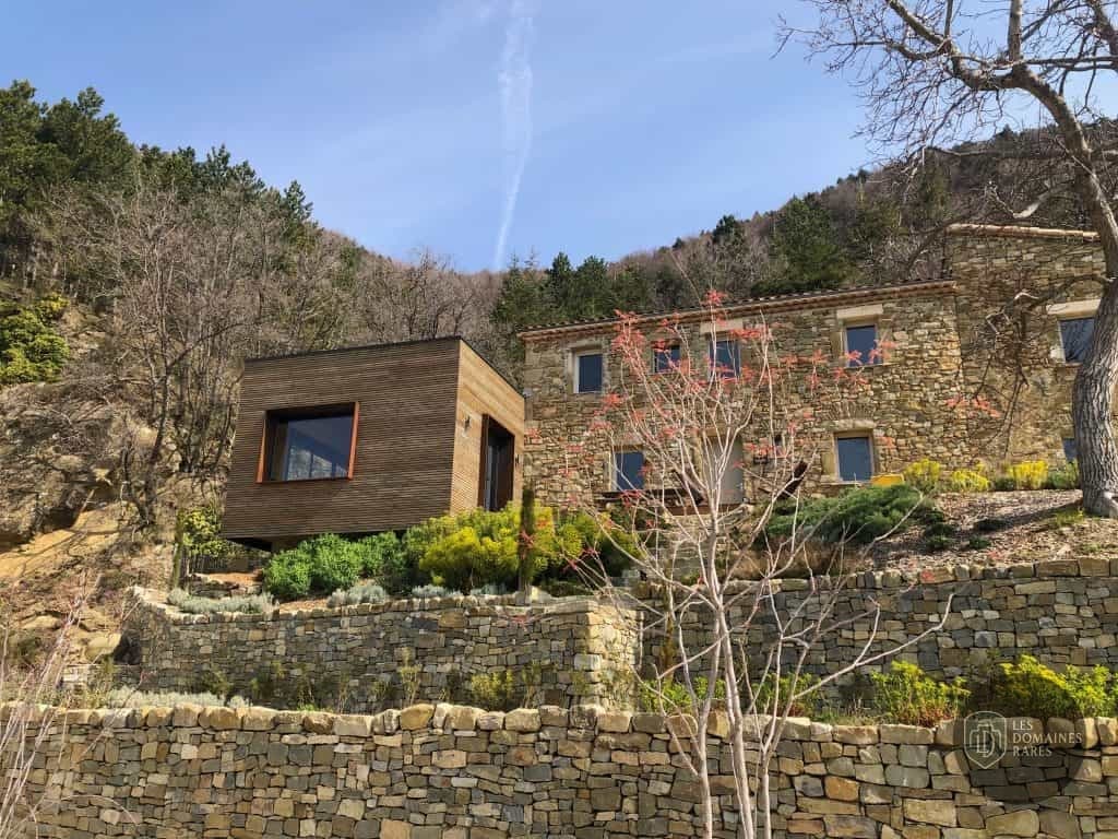 Bâtiment en pierre et extension boisée