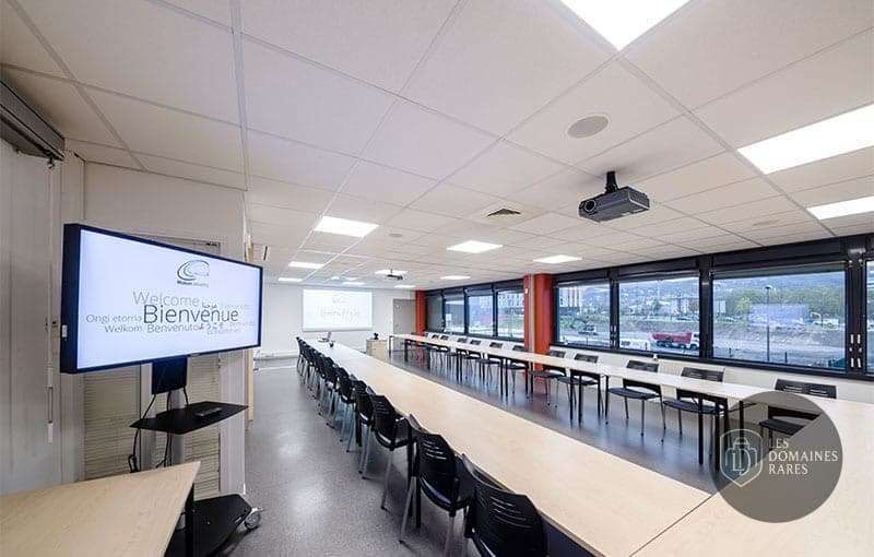 Salle de réunion avec tables et écran