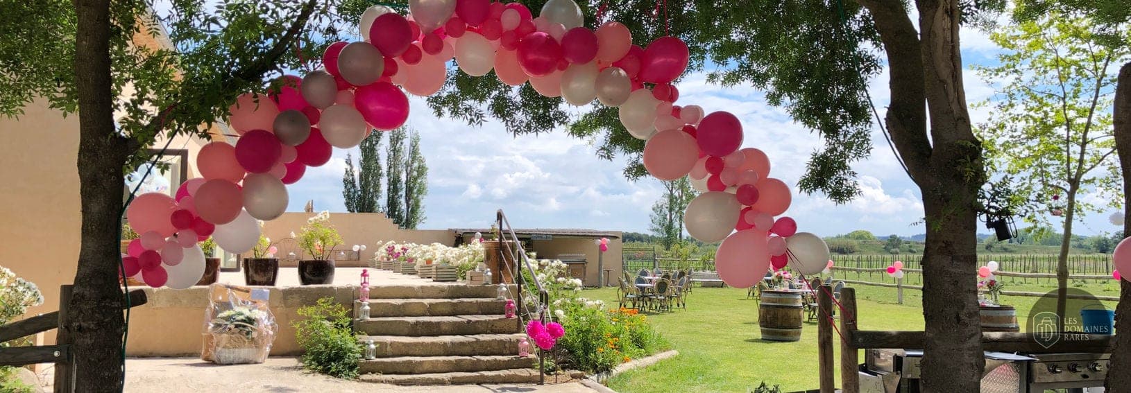 Extérieur fleuri, arche de ballons roses