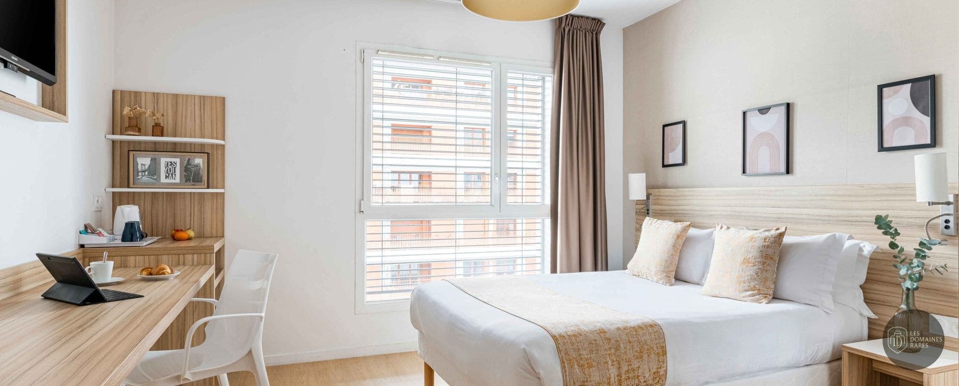 Chambre lumineuse avec bureau et lit